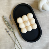 Black concrete oval tray with bubble candle from above