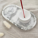 White concrete incense holder on marble oval tray