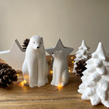 Polar bear family christmas ornaments. Concrete white snowy tree decorations and concrete freestanding star ornaments behind