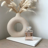 White rectangle concrete display platform with H&M Donut vase and coco Chanel perfume