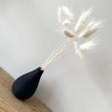 small black concrete bud vase with white bunny tails