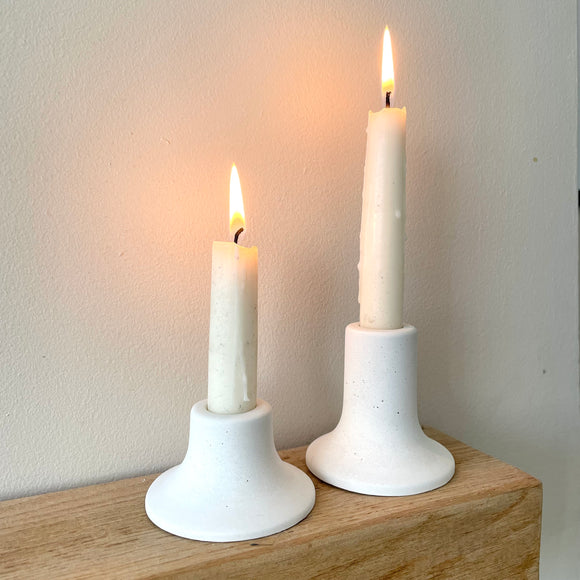 A set of white candlestick holders in different heights. Handmade from concrete by a small business in Kent UK
