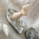 Marble concrete teardrop shaped dish with lady body candle displayed on the tray