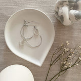 White teardrop shaped concrete tray holding jewellery